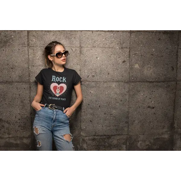 Junge Frau lehnt an einer Wand und trägt ein Rock T-Shirt für Frauen mit Rock-Heart-Design.