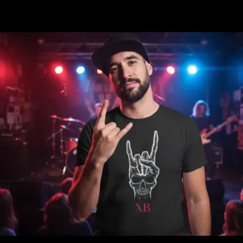 Mann in einer Band-Location trägt ein Premium Rock T-Shirt für Männer mit Devilshorn Skull-Hand-Design.