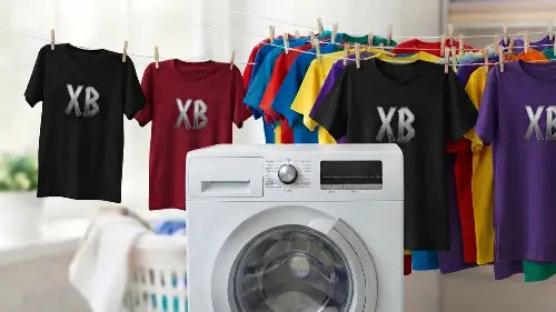 Verschiedene Premium Rock T-Shirts mit dem Aufdruck XB sowie diverse bunte andere T-Shirts auf Wäscheleine im Waschmaschinen-Raum.