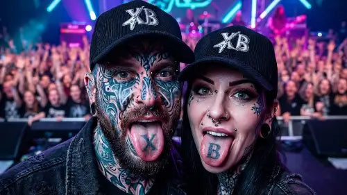 Ein Paar auf einem Konzert streckt die Zunge raus: Beide tragen ein schwarzes Premium Rock Cap aus 100% Bio-Baumwolle mit hochwertigem XB-Stick-Design.