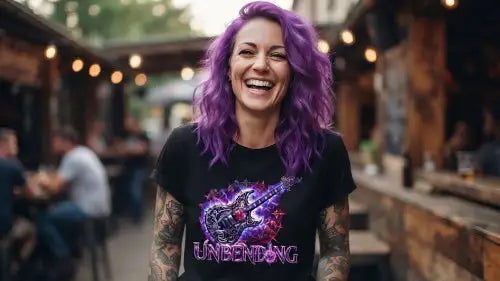 Tätowierte Frau mit lila Haaren trägt ein schwarzes Premium Rock T-Shirt mit violett/ blauem E-Gitarren-Design und Unbending-Schriftzug in einer Bar.