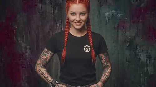 Rothaarige junge Frau mit Zöpfen und Tattoos trägt schwarzes Premium Rock T-Shirt mit XB-Brandig aus Öko-Tex zertifizierten Farben sowie einer Grammatur von 180g/m² aus 100 % Bio-Baumwolle.