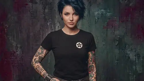 Rockige Frau mit Tattoos trägt hochwertiges schwarzes Premium Rock T-Shirt aus 100 % Bio-Baumwolle in einer Grammatur von 180g/m² mit XB Logo Design aus Öko-Tex zertifizierten Farben.