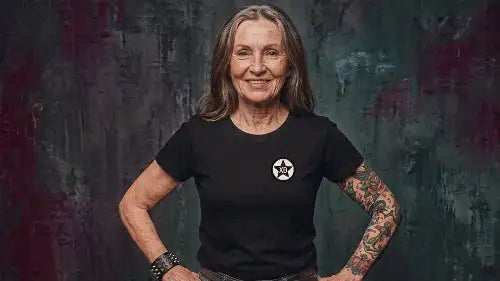 Ältere Frau trägt schwarzes Premium Rock T-Shirt aus 100 % Bio-Baumwolle mit einer Grammatur von 180g/m² sowie hochwertigem XB Logo aus Öko-Tex zertifizierten Farben.