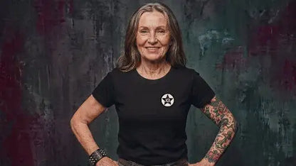 Ältere Frau trägt schwarzes Premium Rock T-Shirt aus 100 % Bio-Baumwolle mit einer Grammatur von 180g/m² sowie hochwertigem XB Logo aus Öko-Tex zertifizierten Farben.