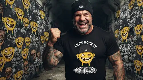 Reifer Mann mit Bart trägt schwarzes Premium Rock T-Shirt mit einem Monster-Smiley aus Öko-Tex zertifizierten Farben in einer Grammatur von 185g/m² aus 100% gekämmter Baumwolle.