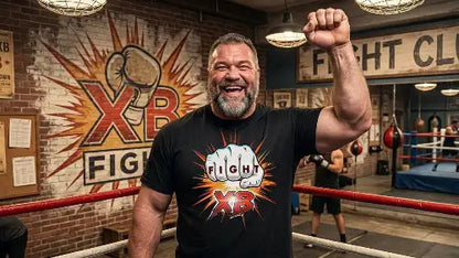 Reifer Mann steht im Ring von Boxing-Club und trägt hochwertiges schwarzes Premium Rock T-Shirt aus 100 % gekämmter Baumwolle mit komplexem Faust Design aus Öko-Tex zertifizierten Farben sowie einer Grammatur von 185g/m².