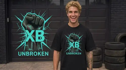 Junger blonder Mann steht lachend vor Garage und trägt ein hochwertiges schwarzes Premium Rock T-Shirt aus 100 % Bio-Baumwolle im Oversize Stil und einer Grammatur von 240g/m² mit komplexem Faust Design aus Öko-Tex zertifizierten Farben.
