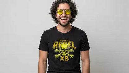 Lachender Mann mit schwarzem Premium Rock T-Shirt mit gelbem Totenkopf-Print und THE REAL REBEL XB Schriftzug.