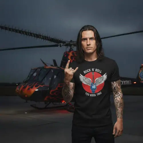 Rockstar vor Hubschrauber trägt ein Premium Rock T-Shirt für Männer mit Flügel-Gitarre-Design.