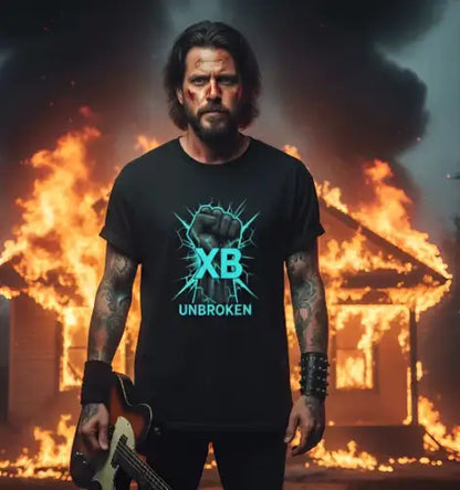 Mann vor brennendem Haus trägt ein Premium Rock T-Shirt für Männer mit UNBROKEN-Design.