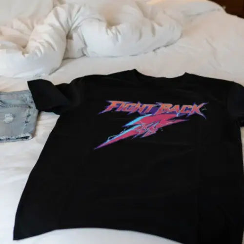 Auf einem Bett liegt ein  Premium Rock T-Shirt für Männer mit komplexem Fight-Design.